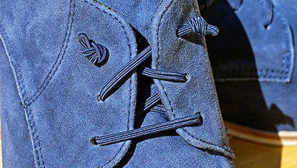 Close up of a laced blue shoes from www.mcconnellshoes.co.uk, one of the portfolio Magento websites of 67 Commerce